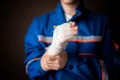 injured worker in uniform isolated on dark background