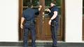 Two police office knocking on the door.