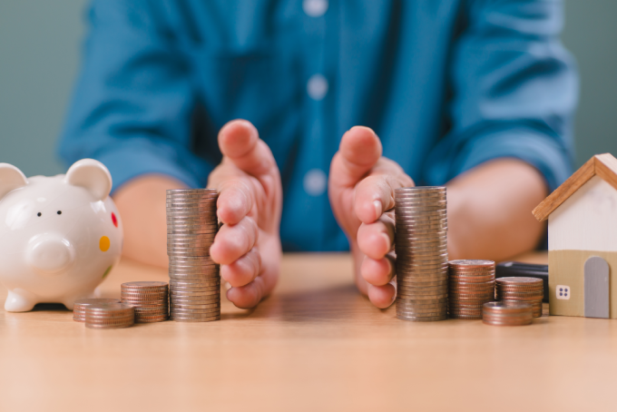 Divorce law and heritage separation concept. Hand separate saving money, financial, home loan, debt with piggy bank and wood house.