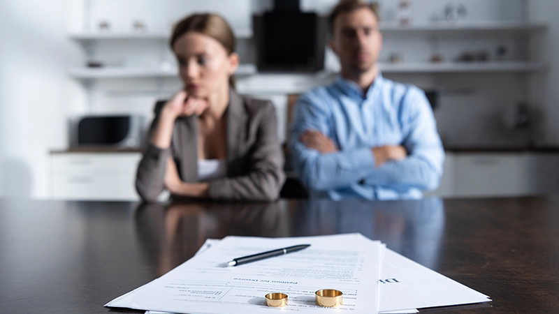 A couple sitting at table with divorce documents.